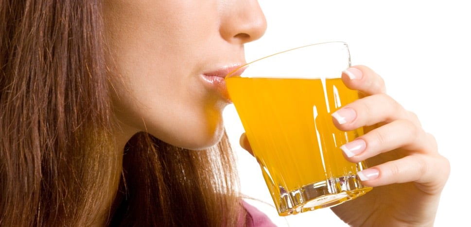 Žena pije pomerančový nápoj
