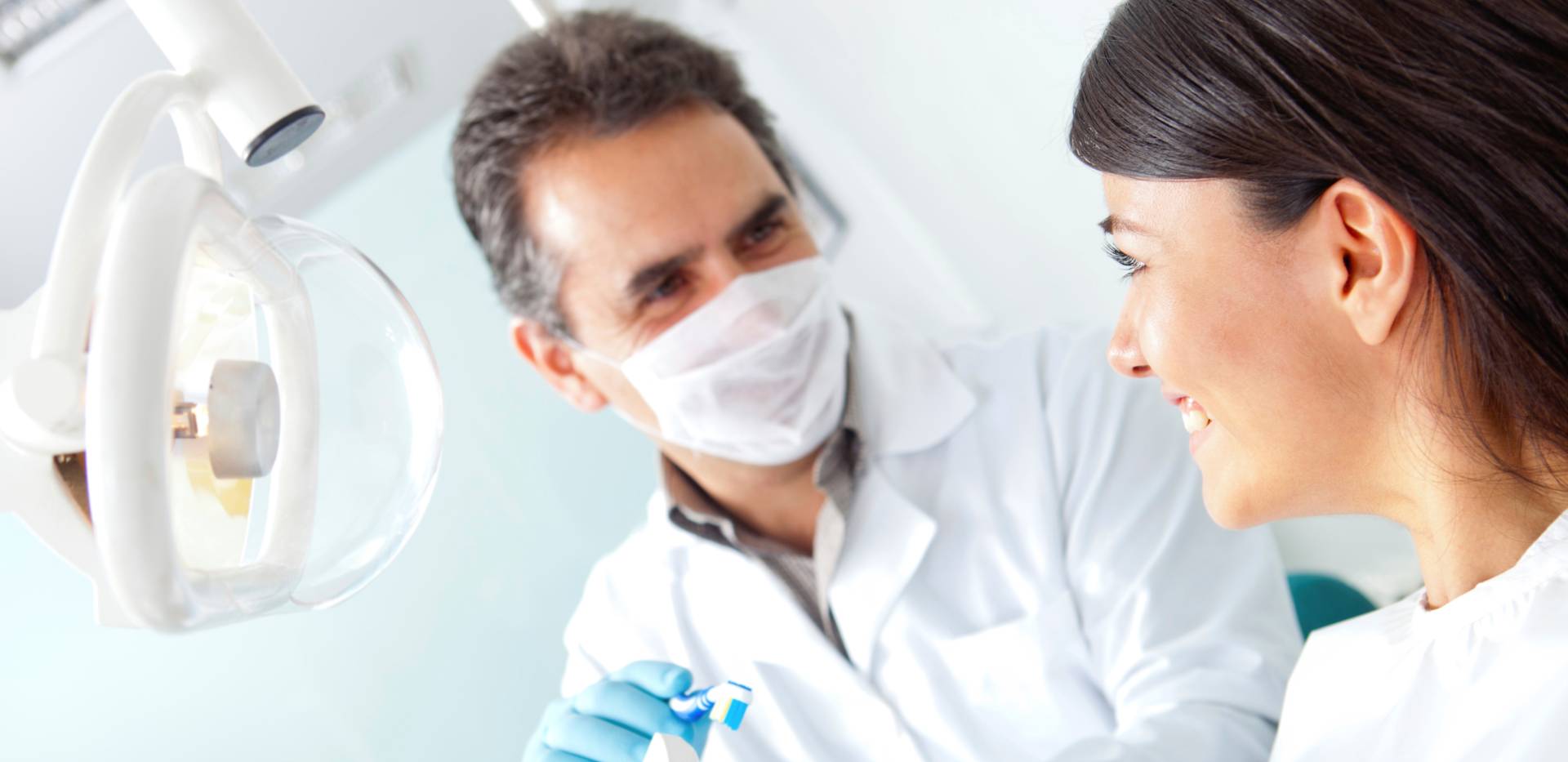 Zubní lékař mluví s pacientkou o ústní hygieně.
