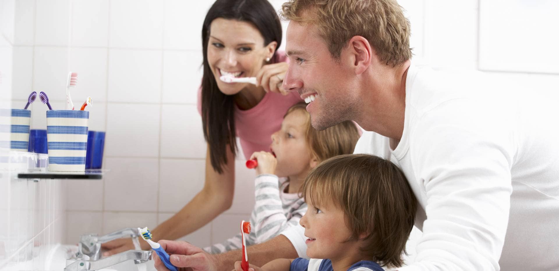 Rodina si společně čistí zuby v koupelně.