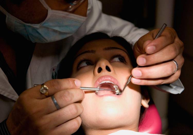 Zubní vyšetření pomocí zrcátka a zubního nástroje.