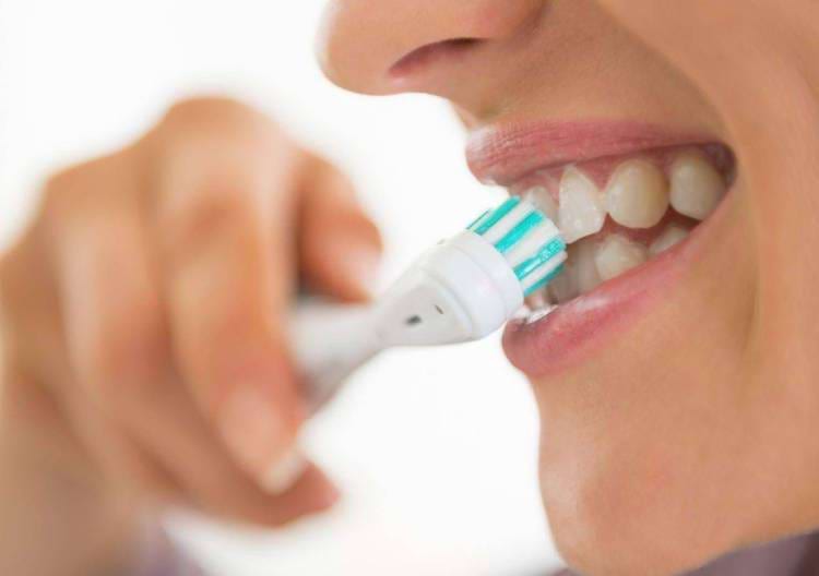 Člověk čistící si zuby zubním kartáčkem.