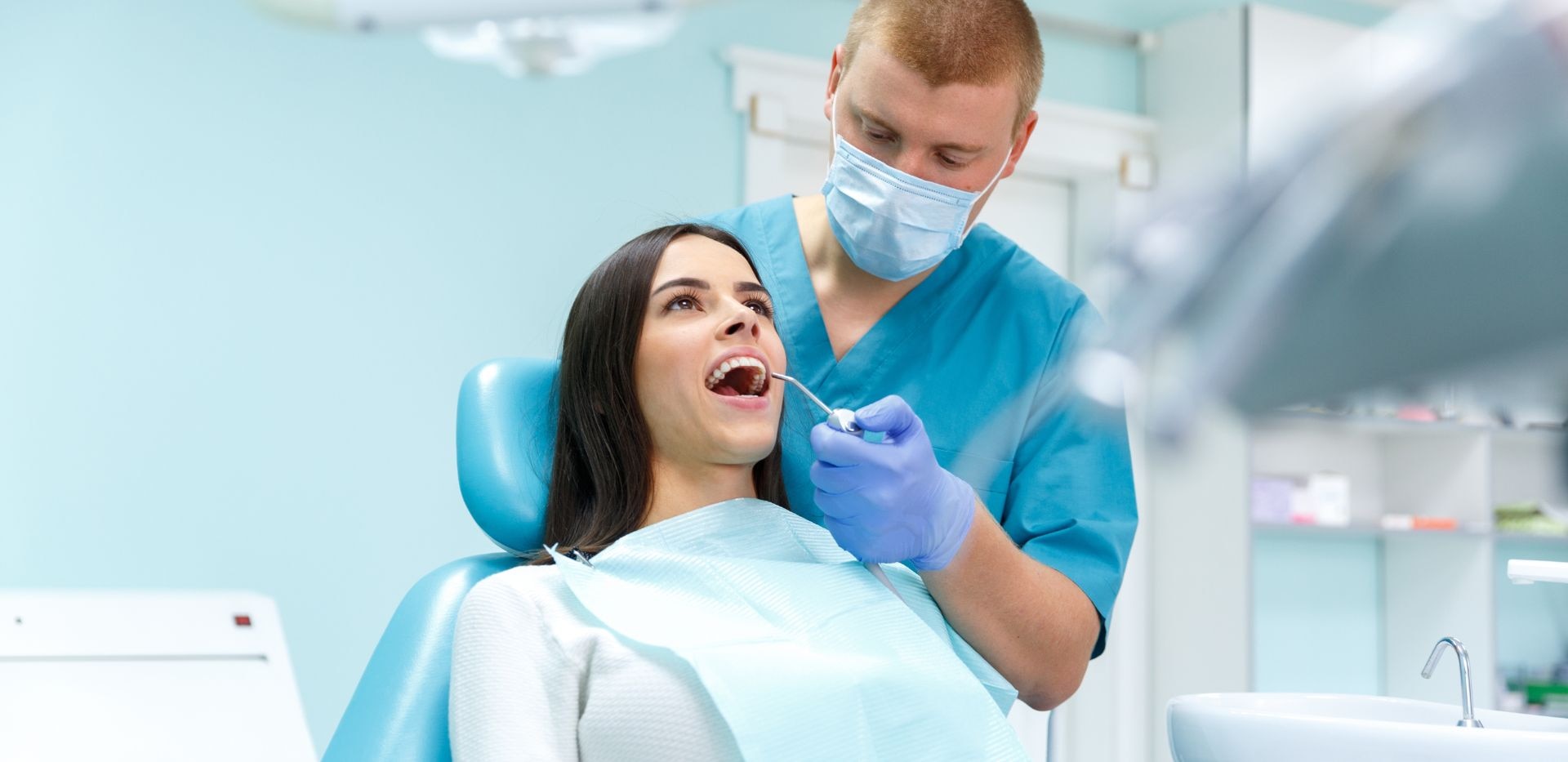 Žena na zubařském křesle během kontroly u zubaře.