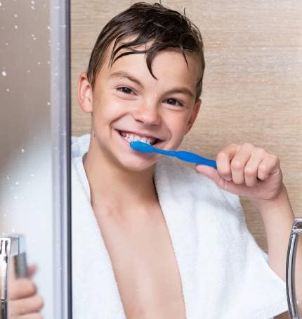 Chlapec si čistí zuby v koupelně.